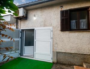 a building with a door and a window and green grass at Sea Mona in Tivat +38 photos