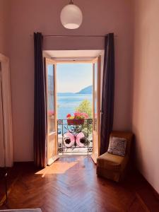 a room with a door to a balcony with a view at Casa Gambusso historical house magnificent Lake View in Verbania
