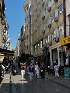 a group of people walking down a busy city street at Denizli Hotel in Istanbul
