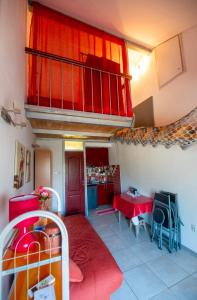 a small room with a red table and a balcony at Sea Mona in Tivat
