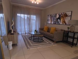 a living room with a couch and a table at Classy and Cosy 5 in Fourways