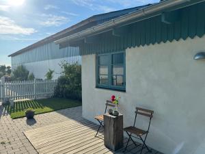 a house with two chairs and a table on a deck at Tiny Guesthouse in Nakskov