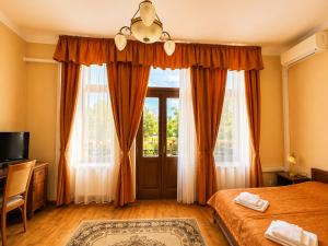 a bedroom with a bed and a large window at Olymp penzion in Komárno