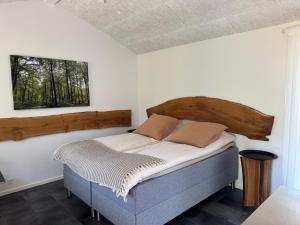 a bedroom with a bed with a wooden headboard at Tiny Guesthouse in Nakskov +62 photos