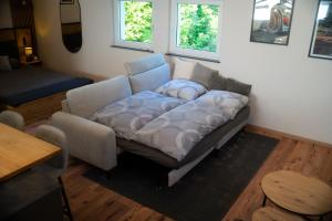 a couch sitting in a living room with a table at Ferienhaus Lenz in Kalenborn +14 photos