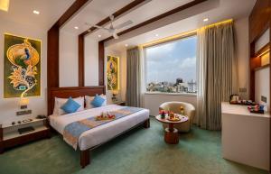 a hotel room with a bed and a large window at Dwarkadhish Lords Eco Inn Dwarka - Pure Veg in Dwarka +129 photos