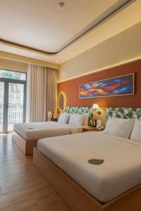 a hotel room with two beds and a large window at NiK Hotel Hillside Da Lat in Da Lat