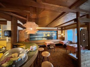 a living room with a chandelier and tables and chairs at Hotel Milan - Self Check-In in Ringgenberg