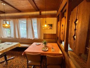 a dining room with a red table and chairs at Hotel Milan - Self Check-In in Ringgenberg