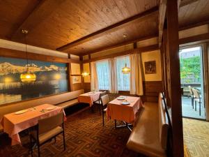 a restaurant with two tables in a room at Hotel Milan - Self Check-In in Ringgenberg