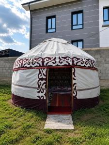 a yurt with a table in it in front of a house at Eagle's Nest in Karakol