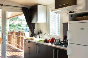 a kitchen with a white refrigerator and a stove top oven at Bungalow Chalet sulla Spiaggia in Chioggia +19 photos
