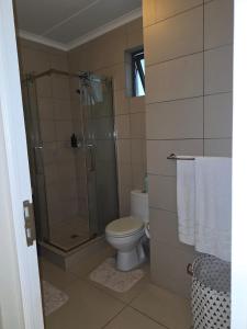 a bathroom with a toilet and a glass shower at Classy and Cosy 5 in Fourways +15 photos