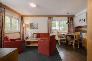 a living room with red chairs and a table at Appartement Désirée inkl der SUPER SOMMER CARD im SOMMER 2026 in Serfaus