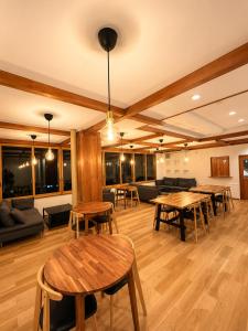 a room with tables and chairs and a couch at Snow Palace Nozawa in Nozawa Onsen