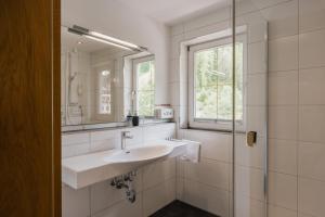 a white bathroom with a sink and a mirror at Appartement Désirée inkl der SUPER SOMMER CARD im SOMMER 2026 in Serfaus +65 photos