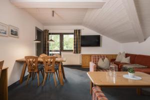 a living room with a table and chairs and a couch at Appartement Désirée inkl der SUPER SOMMER CARD im SOMMER 2026 in Serfaus