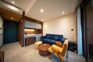 a living room with a blue couch and a table at Padang Padang Inn in Uluwatu