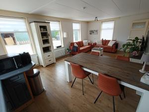 a living room with a wooden table and chairs at 't Skoallehus in Steggerda