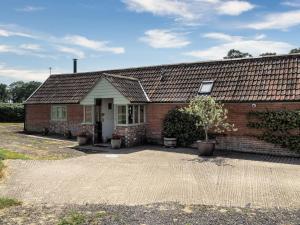 a red brick house with a white door at Downclose Piggeries in North Perrott