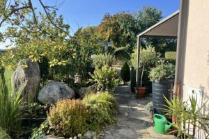 a garden with plants and rocks and a building at Kleine Bella in Ilmmünster