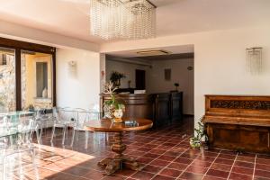 a living room with a table and a piano at Hotel Resort La Rosa Dei Venti in Portopalo