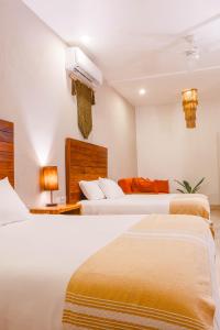 a hotel room with two beds and a air conditioner at Collection O Kaab Downtown Tulum in Tulum