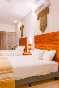a hotel room with two beds and a air conditioner at Collection O Kaab Downtown Tulum in Tulum