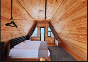 a bedroom with a large bed in a wooden room at ALTO Cabins in Alamedin