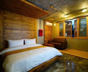 a bedroom with a large bed and a couch at Hwangsil Tourist Hotel Seojoong in Jeonju