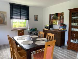 a dining room with a table and chairs and a television at Dworek na Polance in Wrzosowo