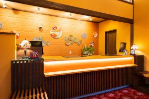 a room with a large bed with an orange wall at Seaside Hotel Mimatsu Ooetei in Beppu +164 photos