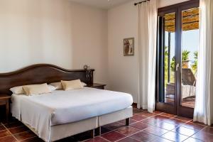 a bedroom with a bed and a sliding glass door at Hotel Resort La Rosa Dei Venti in Portopalo