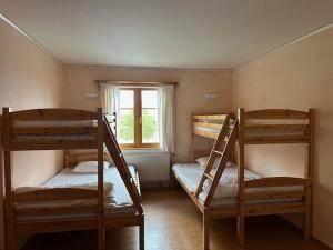 three bunk beds in a room with a window at Saxnäsgården Hotell in Saxnäs