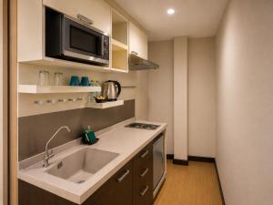 a kitchen with a sink and a microwave at Suk41 Bangkok Hotel in Bangkok +29 photos