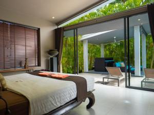 a bedroom with a bed and a large glass window at 3Br Villa Yin Kuo Private Pool Walk to Beach in Mae Nam