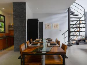 a dining room with a table and chairs and a staircase at 3Br Villa Yin Kuo Private Pool Walk to Beach in Mae Nam