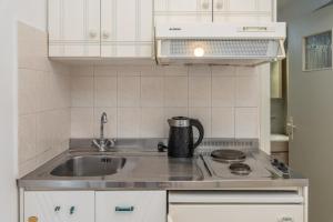 a small kitchen with a sink and a stove at Dionysios Studios in Skala +55 photos