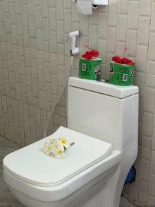 a white toilet with flowers on the top of it at Nyota Apartment in Nungwi