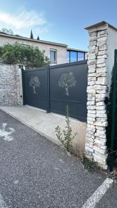 a black fence with trees on it next to a driveway at Appartement avec Terrasse et piscine in Gréoux-les-Bains