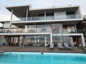 a large house with a swimming pool in front of it at The Ocean View Guest House in Wilderness