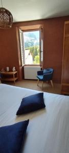 a bed with a pillow on it in a room with a window at Auberge Buissonniere in Gresse-en-Vercors