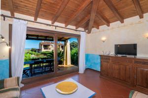 ein Wohnzimmer mit Fernseher und Balkon in der Unterkunft Villa Mariluce in Cuile Pazzoni