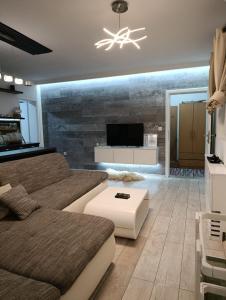 a living room with a couch and a tv at Cozy apartment with garden in Sarajevo