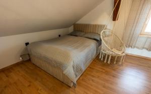 a small bedroom with a bed and a chair at RANČ Dida in Ženavlje