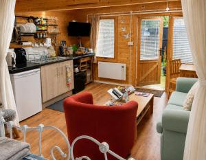 eine Küche und ein Wohnzimmer mit Sofa und Tisch in der Unterkunft SherPai Lodge in Kent + 8 Fotos