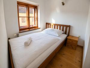 a bedroom with a large white bed with a window at MiMo penzion in Telč