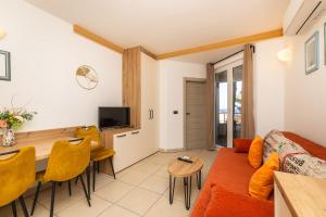 a living room with a couch and a dining room table at Sanpier Apartments in Veli Lošinj