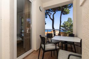 a balcony with a table and chairs and a view of the ocean at Sanpier Apartments in Veli Lošinj