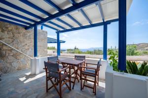 a patio with a wooden table and chairs at Niel Serifos in Serifos Chora
